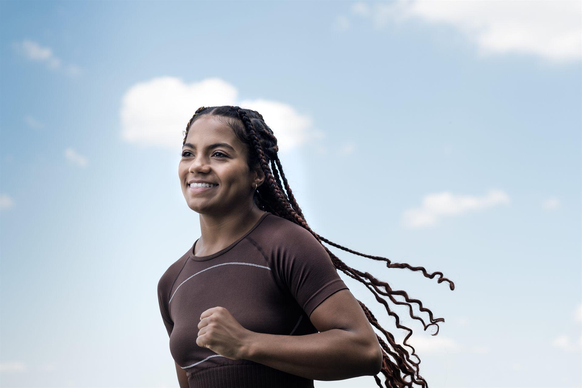 A woman jogging outdoors, supported by long-term primary care